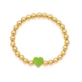 Gedetailleerd zicht op een goudkleurige kralenarmband met een groene hart hanger - Lichtgroen