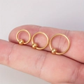 Three gold stainless steel captive bead rings in various sizes held on a fingertip - 3-Piece Set (8mm+10mm+12mm) / Gold