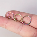 Macro view of three rainbow stainless steel captive bead rings held on fingertips - 3-Piece Set (8mm+10mm+12mm) / Colorful