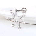 Vue macro d'une boucle d'oreille étoile en acier argenté avec boules sur un plat en céramique - Clou d'Oreille Étoile Engrenage (Style-9)