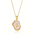 Macro-opname van retro hanger letter K met gouden lavatectuur en parelmoer basis - Goud K