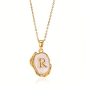 Detail van vintage gouden ketting met letter R hanger en wit parelmoer inlegwerk - Goud R