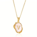 Macro detail van gouden vintage ketting met letter V hanger en parelmoer glans op fijne ketting - Goud V