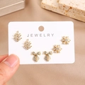 Macro shot of gold-plated leaf, snowflake, and bow earrings set with white zircons - Leaf Snowflake And Bowknot Style (0026-5)