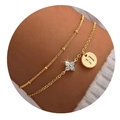 Detail van gouden dubbele armband met letter H hanger en klavertje met zirkonia - Letter H