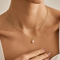 Detailopname van een dubbellaagse gouden kettingset met een glanzende parelhanger - Enkele Druppelparel Stijl (xp-154)