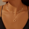Detail van de dubbellaagse gouden paperclipketting en ronde gedraaide hanger op model - Holle Gedraaide Cirkel Stijl (xp-134)