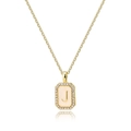 Close-up of golden letter J shell pendant with sparkling zircon and rectangle frame - Letter J