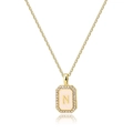 Close-up of gold square necklace with pink shell and letter N inlaid with zircons - Letter N