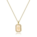 Macro shot of gold square pendant with pink enamel letter Q and zircon border inlay - Letter Q