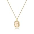 Macro view of gold initial T pendant with zircon border and shell enamel background - Letter T
