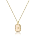 Detailed close-up of golden rectangular letter U pendant with pink shell and zircons - Letter U
