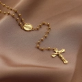 Macro shot of 18K gold plated rosary necklace with cross and Mary medal on silk - Virgin Mary Cross Rosary Style / Gold