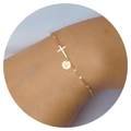 Detailed close-up of gold chain bracelet with cross charm and engraved letter V disk - Letter V
