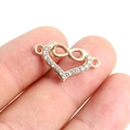Macro shot of gold infinity heart charm with white rhinestones for DIY bracelet making - Gold Infinity Heart Rhinestone Connector