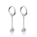 Detail of silver drop earrings with cross chains and white round pearls in close-up - Cross Thin Chain Pearl Dangle Style