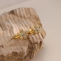 Macro view of 18K gold plated flower earrings featuring zircon crystals on stone - White
