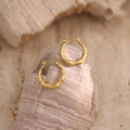 Dettaglio macro di orecchini a cerchio dorati con trama in bambù su pietra - Design Cerchio Bambù Sottile (EH333)