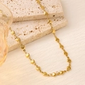 Close-up of 18K gold plated heart chain link necklace on a textured stone display - Linked Heart Chain Necklace (XL112)