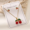 Vista macro del set collana e orecchini a ciliegia in acciaio inossidabile placcato oro 18K - Stile Ciliegia Doppia Frutta (TZ026)