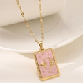 Macro detail of sun and moon relief on pink enamel tarot pendant with gold chain - Light Pink