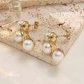 Detail of elegant triple pearl stud earrings with gold setting on a beige stone surface - Triple Pearl Curved Style (EH565)