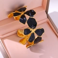 Luxe goudkleurige open armband met zwarte emaille bloemblaadjes in een geschenkdoos - Zwart