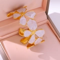 Elegante gouden bloem armband met roze emaille bloemblaadjes op een luxe sieradendoos - Wit