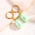 Détail de boucles d'oreilles créoles dorées avec pendentifs ovales en résine verte - Vert Eau Clair & Or