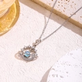 Detailed close-up of a Saturn-shaped snowflake necklace with light blue stone and zircon - Universe Galaxy (Blue Planet / Stars)