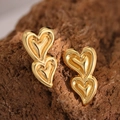Macro shot of double heart gold stud earrings on natural stone for textured jewelry detail - Double Layer Heart (EH102)