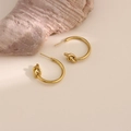 Dettaglio di orecchini a cerchio in acciaio inossidabile placcato oro 18k con nodo decorativo - Stile Cerchio Decorativo con Nodo (EH190)