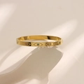 Detail of gold evil eye bangle with colorful zircon stones on white rock display - Colorful Zircon Evil Eye Style (SZ005)