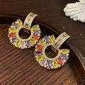 Close-up of golden C-shaped earrings with colorful marquise-cut zircons and micro-pave crystals - Gold-Multicolor