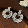 Macro detail of silver C-shaped drop earrings with marquise and round cubic zirconia stones - Silver-White