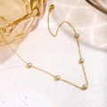 Collier minimaliste en chaîne dorée avec cinq perles serties sur une surface en pierre - Collier de perles blanches / Or