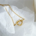 Detailed view of 18K gold plated knotted heart pendant necklace on white background - Necklace / Gold