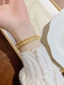 Detail of three-piece gold titanium steel bracelets showing matte and polished finishes - Size 65 / Gold
