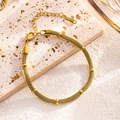 Golden mesh chain bracelet with round metal beads and lobster clasp on stone tray - Bamboo Mesh Bracelet (7791) / Gold