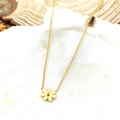 Élégant collier avec pendentif marguerite en or rose sur un fond décoratif de coquillage - Or