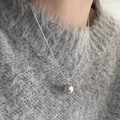 Elegant silver necklace with large dark grey pearl pendant on a grey knitted sweater - Silver-Grey Pearl