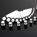 Dehnungstab Set aus weißem Acryl mit Plugs und Tapers auf schwarzem Untergrund - Set mit weißen Zirkonia