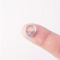 Gros plan d'un anneau de nez alien en acier inoxydable posé sur le bout des doigts - 8mm / Argent