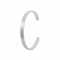 Detailed macro view of silver C-shaped stainless steel cuff with vintage matte finish - Original Etched / Steel