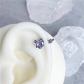 Macro shot of heart-shaped lavender zircon earring set on a white silicone ear model - Heart Purple And White (Steel Color Bar)