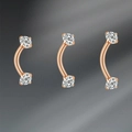 Detailed macro view of three rose gold curved barbells with sparkling zircon stones - Rose Gold Zirconia Inlaid Style