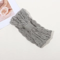 Winter light grey cable knit headband with center bow design on textured background - Gray