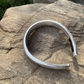 Metallic silver PU leather padded headband with a handmade label on a stone background - Silver Leather Padded Headband