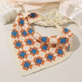 Detailed macro view of handmade crochet floral bandana with blue and orange flower patterns - Blue Red
