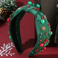 Diadema navideña verde con perlas rojas y lazos dorados sobre fondo festivo decorativo - Verde